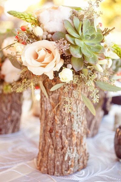 Tree Stump Vases Filled With Flowers As Fall Wedding Centerpiece. 